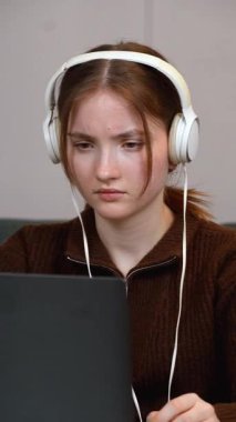 Uzaktan kumandayla çalışan profesyonel serbest çalışan genç öğrenci bilgisayar oyunları, zihinsel yorgunluk, kulaklık takmak ve işle ilgili stres belirtileri göstermek.