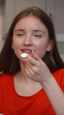 Genç, cam masada oturmuş, günlük evde besleyici atıştırmalıkların tadını çıkarırken,... kaymak gibi yoğurdun tadını çıkarıyor.