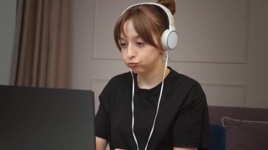 Ses geçirmez kulaklıklar takan, uzaktan kumandalı bilgisayar başında çalışan duygusal ve şaşırtıcı video görüşmelerine katılan ev işyerindeki mesleki görevine odaklanan serbest çalışan bir kadın.