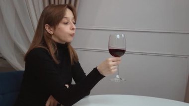 Mutfakta elinde bir bardak kırmızı şarapla orta yaşlı, tatlı bir kadın. Mutfakta şarap içen düşünceli, çok kültürlü genç bir kadın. Hayatı ve planları yansıtıyor..