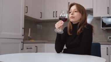 Mutfakta elinde bir bardak kırmızı şarapla orta yaşlı, tatlı bir kadın. Mutfakta şarap içen düşünceli, çok kültürlü genç bir kadın. Hayatı ve planları yansıtıyor..