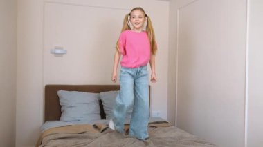 Enerjik genç kız sınırsız bir neşeyle yatağa atlıyor, günlük pembe gömlek ve kot pantolon giyiyor, tasasız çocukluk mutluluğunu ve neşeli özgürlüğü simgeliyor.
