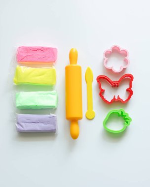 Çocukların yaratıcılığına göre ayarlanmış. Plasticinle kalıba dökmek için malzemeler ve aletler. Beyaz arka plan. Üst görünüm