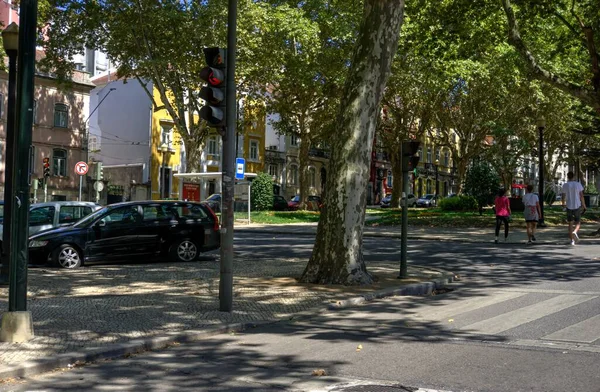 stock image Coimbra, Portugal - August 15, 2022: Street view showing tree-lined streets, pedestrians and parked cars