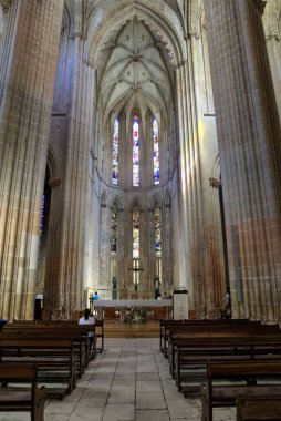 Batalha, Portekiz - 15 Ağustos 2022: Haçlı, vitray pencereli, sıralı ve turistli gotik manastırın içi