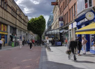 Dublin, İrlanda - 14 Haziran 2024: Güney King Caddesi 'nin Gaiety Tiyatrosu' nu, dükkanları ve restoranlarını gösteren görüntüsü yayaları bulanıklaştırdı