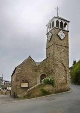 Looe, Cornwall, UK - October 25, 2021: Exterior view of St Nicholas church showing entrance door, bell tower and two clock faces clipart