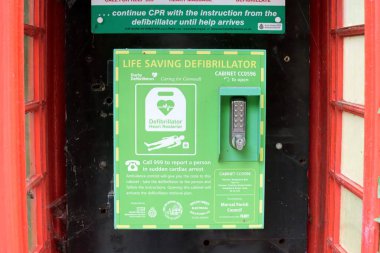 Sandplace, Cornwall, İngiltere - 23 Ekim 2021: Değiştirilmiş kırmızı telefon kulübesi içinde defibrilatör kullanma talimatları