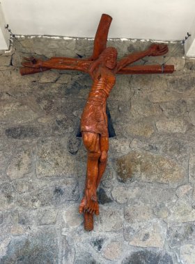 Chimbote, Peru - January 4, 2023: Large wooden Crucifix showing Christ on the Cross on wall of church of the Hill of Peace clipart