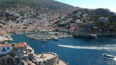 Hava aracı, gün batımında pitoresk liman ve Hydra (veya Ydra) adasının ana köyünün panoramik fotoğrafını çeker. Hydra, Yunanistan 'ın Saronik Körfezi' nde bulunan neoklasik evleri ile önde gelen turizm merkezlerinden biri..