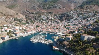 Hava aracı, gün batımında pitoresk liman ve Hydra (veya Ydra) adasının ana köyünün panoramik fotoğrafını çeker. Hydra, Yunanistan 'ın Saronik Körfezi' nde bulunan neoklasik evleri ile önde gelen turizm merkezlerinden biri..