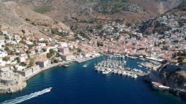 Hava aracı, gün batımında pitoresk liman ve Hydra (veya Ydra) adasının ana köyünün panoramik fotoğrafını çeker. Hydra, Yunanistan 'ın Saronik Körfezi' nde bulunan neoklasik evleri ile önde gelen turizm merkezlerinden biri..