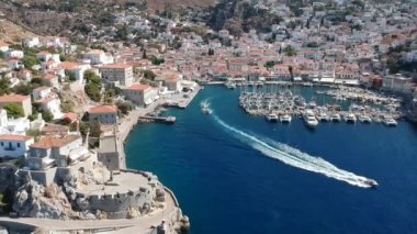 Hava aracı, gün batımında pitoresk liman ve Hydra (veya Ydra) adasının ana köyünün panoramik fotoğrafını çeker. Hydra, Yunanistan 'ın Saronik Körfezi' nde bulunan neoklasik evleri ile önde gelen turizm merkezlerinden biri..