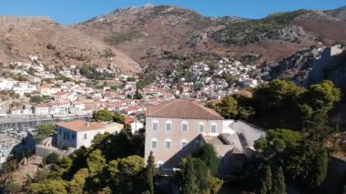 Hava aracı, gün batımında pitoresk liman ve Hydra (veya Ydra) adasının ana köyünün panoramik fotoğrafını çeker. Hydra, Yunanistan 'ın Saronik Körfezi' nde bulunan neoklasik evleri ile önde gelen turizm merkezlerinden biri..