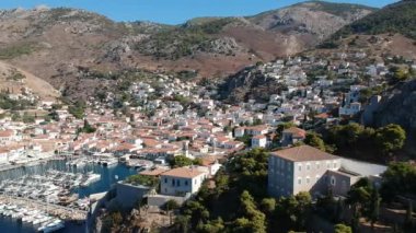 Hava aracı, gün batımında pitoresk liman ve Hydra (veya Ydra) adasının ana köyünün panoramik fotoğrafını çeker. Hydra, Yunanistan 'ın Saronik Körfezi' nde bulunan neoklasik evleri ile önde gelen turizm merkezlerinden biri..