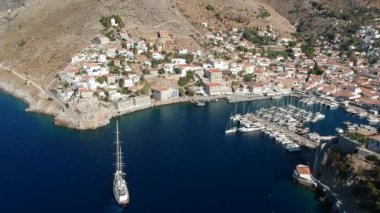 Hava aracı, gün batımında pitoresk liman ve Hydra (veya Ydra) adasının ana köyünün panoramik fotoğrafını çeker. Hydra, Yunanistan 'ın Saronik Körfezi' nde bulunan neoklasik evleri ile önde gelen turizm merkezlerinden biri..