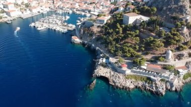 Hava aracı, gün batımında pitoresk liman ve Hydra (veya Ydra) adasının ana köyünün panoramik fotoğrafını çeker. Hydra, Yunanistan 'ın Saronik Körfezi' nde bulunan neoklasik evleri ile önde gelen turizm merkezlerinden biri..
