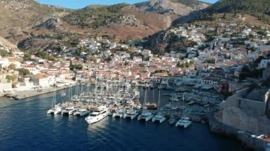 Hava aracı, gün batımında pitoresk liman ve Hydra (veya Ydra) adasının ana köyünün panoramik fotoğrafını çeker. Hydra, Yunanistan 'ın Saronik Körfezi' nde bulunan neoklasik evleri ile önde gelen turizm merkezlerinden biri..