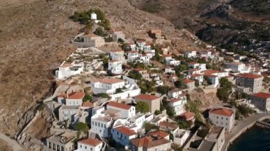 Hava aracı, gün batımında pitoresk liman ve Hydra (veya Ydra) adasının ana köyünün panoramik fotoğrafını çeker. Hydra, Yunanistan 'ın Saronik Körfezi' nde bulunan neoklasik evleri ile önde gelen turizm merkezlerinden biri..