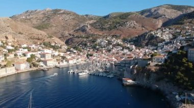 Hava aracı, gün batımında pitoresk liman ve Hydra (veya Ydra) adasının ana köyünün panoramik fotoğrafını çeker. Hydra, Yunanistan 'ın Saronik Körfezi' nde bulunan neoklasik evleri ile önde gelen turizm merkezlerinden biri..