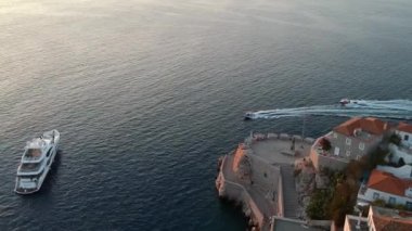 Hava aracı, gün batımında pitoresk liman ve Hydra (veya Ydra) adasının ana köyünün panoramik fotoğrafını çeker. Hydra, Yunanistan 'ın Saronik Körfezi' nde bulunan neoklasik evleri ile önde gelen turizm merkezlerinden biri..