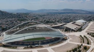 Atina, Atina 'daki OAKA Olimpiyat Stadyumu üzerindeki ikonik hava manzarası, Santiago Calatrava tarafından güzel bulutları ve Atina' nın Marusya kentinde mavi gökyüzü ile tasarlandı