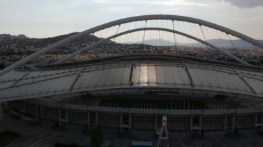 Atina, Atina 'daki OAKA Olimpiyat Stadyumu üzerindeki ikonik hava manzarası, Santiago Calatrava tarafından güzel bulutları ve Atina' nın Marusya kentinde mavi gökyüzü ile tasarlandı