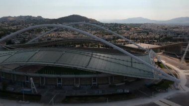 Atina, Atina 'daki OAKA Olimpiyat Stadyumu üzerindeki ikonik hava manzarası, Santiago Calatrava tarafından güzel bulutları ve Atina' nın Marusya kentinde mavi gökyüzü ile tasarlandı