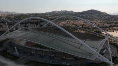 Atina, Atina 'daki OAKA Olimpiyat Stadyumu üzerindeki ikonik hava manzarası, Santiago Calatrava tarafından güzel bulutları ve Atina' nın Marusya kentinde mavi gökyüzü ile tasarlandı