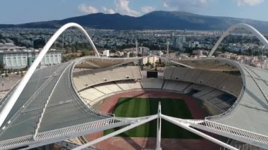 Atina, Atina 'daki OAKA Olimpiyat Stadyumu üzerindeki ikonik hava manzarası, Santiago Calatrava tarafından güzel bulutları ve Atina' nın Marusya kentinde mavi gökyüzü ile tasarlandı