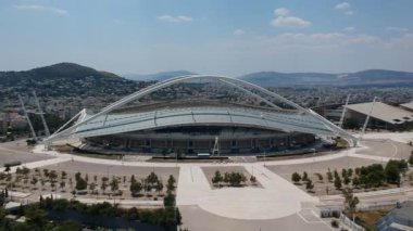 Atina, Atina 'daki OAKA Olimpiyat Stadyumu üzerindeki ikonik hava manzarası, Santiago Calatrava tarafından güzel bulutları ve Atina' nın Marusya kentinde mavi gökyüzü ile tasarlandı