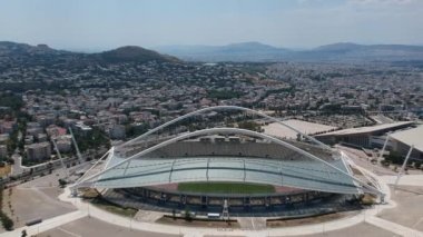 Atina, Atina 'daki OAKA Olimpiyat Stadyumu üzerindeki ikonik hava manzarası, Santiago Calatrava tarafından güzel bulutları ve Atina' nın Marusya kentinde mavi gökyüzü ile tasarlandı