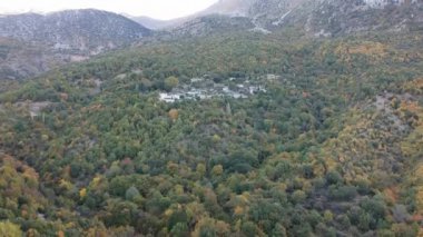 Aerial panoramic view over the picturesque village Papigo in Epirus, Greece at sunset. Scenic aerial view of traditional Greek villages in Autumn. Epirus, Greece, Europe.
