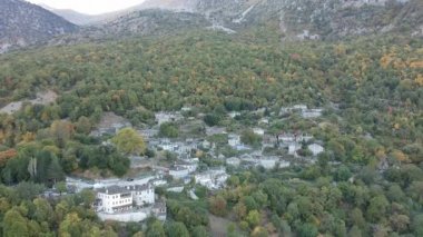 Aerial panoramic view over the picturesque village Papigo in Epirus, Greece at sunset. Scenic aerial view of traditional Greek villages in Autumn. Epirus, Greece, Europe.