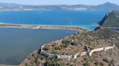 Aerial panorama view over the famous castle of Navarino located on the top of semicircular sandy beach and lagoon, Voidokilia in Messenia, Greece