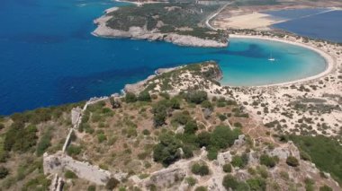 Aerial panorama view over the famous castle of Navarino located on the top of semicircular sandy beach and lagoon, Voidokilia in Messenia, Greece