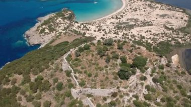 Aerial panorama view over the famous castle of Navarino located on the top of semicircular sandy beach and lagoon, Voidokilia in Messenia, Greece