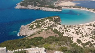 Aerial panorama view over the famous castle of Navarino located on the top of semicircular sandy beach and lagoon, Voidokilia in Messenia, Greece