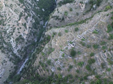 Ridomo Gorge 'daki Mani bölgesinde mekanik basınçlı terk edilmiş taş evler ve değirmenlerin hava görüntüsü. Taygetus dağındaki ünlü Ridomo vadisinden doğal manzara, Messenia, Yunanistan