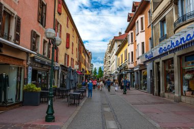 Annecy kasabasının güzel sokaklarında bulutlu bir gökyüzüne karşı yürüyen turistler ve ziyaretçiler. Annecy, Haute Savoie Fransa 'da.