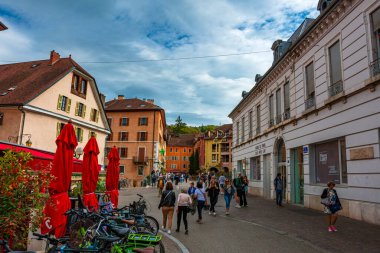 Annecy kasabasının güzel sokaklarında bulutlu bir gökyüzüne karşı yürüyen turistler ve ziyaretçiler. Annecy, Haute Savoie Fransa 'da.