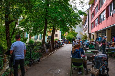 Annecy kasabasının güzel sokaklarında bulutlu bir gökyüzüne karşı yürüyen turistler ve ziyaretçiler. Annecy, Haute Savoie Fransa 'da.