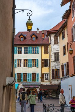 Annecy kasabasının güzel sokaklarında bulutlu bir gökyüzüne karşı yürüyen turistler ve ziyaretçiler. Annecy, Haute Savoie Fransa 'da.