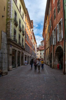 Annecy kasabasının güzel sokaklarında bulutlu bir gökyüzüne karşı yürüyen turistler ve ziyaretçiler. Annecy, Haute Savoie Fransa 'da.