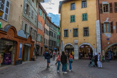 Annecy kasabasının güzel sokaklarında bulutlu bir gökyüzüne karşı yürüyen turistler ve ziyaretçiler. Annecy, Haute Savoie Fransa 'da.