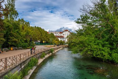 Fransa 'da bulutlu bir gökyüzüne karşı Thiou nehrinin yanı sıra Annecy kasabasının güzel manzarası.