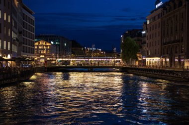 Cenevre, İsviçre 8 Eylül 2023: İsviçre 'de Cenevre şehrinde güzel aydınlatılmış binalarla gece nehir manzarası