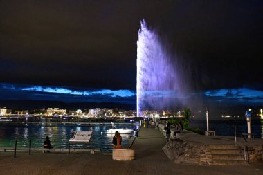 Cenevre, İsviçre 8 Eylül 2023: İsviçre 'nin Cenevre kentindeki büyük bir çeşme olan Jet d' Eau 'nun gece manzarası, kentin en ünlü simgelerinden biridir.
