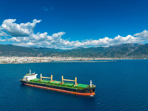 Aerial photo of huge bulk carrier tanker anchored in deep blue Aegean sea.