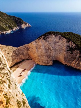 Yunanistan 'ın Zakynthos adasındaki ünlü Navagio plajı (Batık Kumsalı) üzerinde hava manzarası. İyon Denizi 'nin, Navagio' nun ya da Batık Sahili 'nin en güzel mücevherlerinden biri Zakynthos' un dünyaca ünlü doğal görüntüsünden sonra açık ara en popüler mekanıdır.